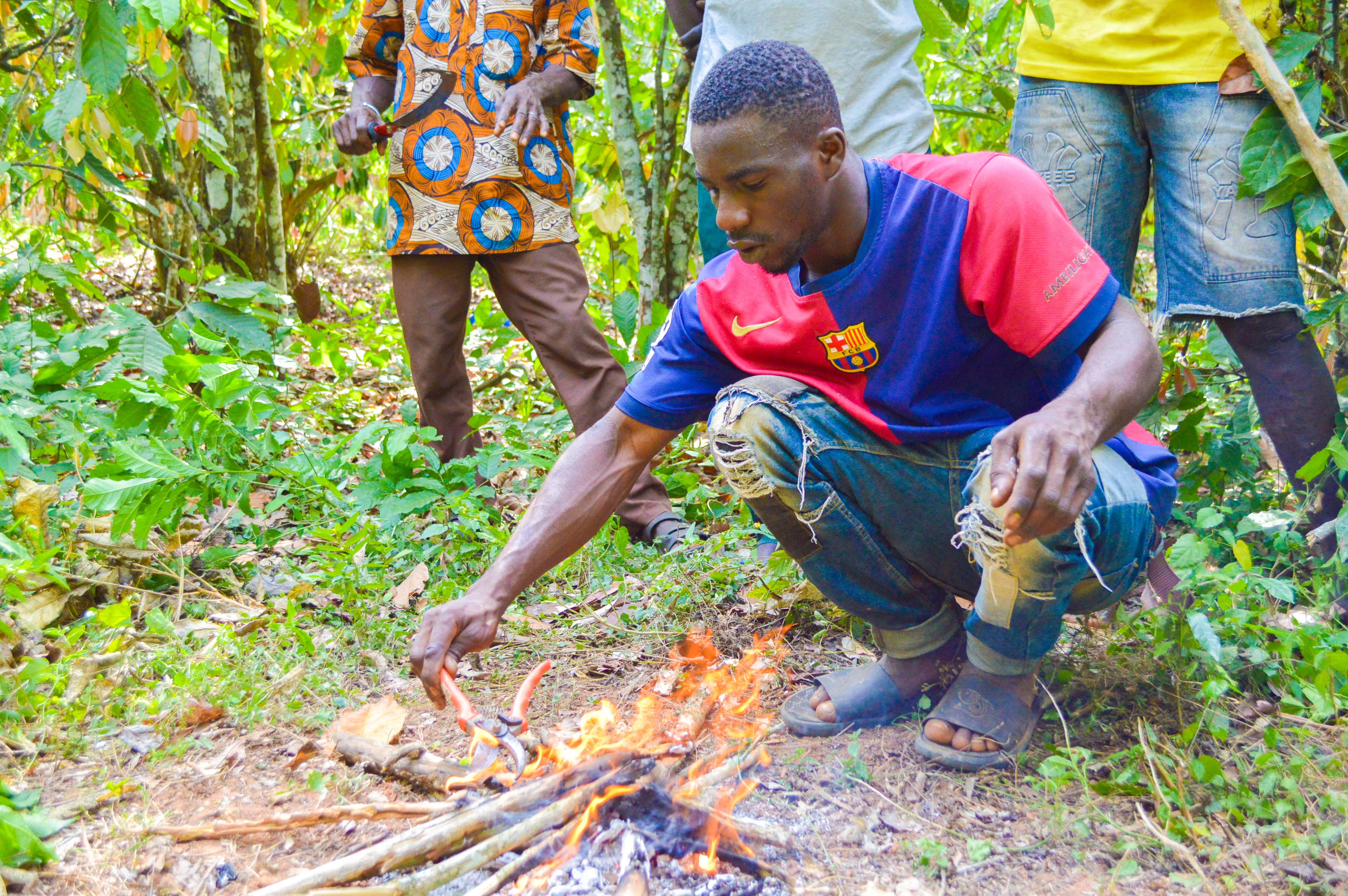 A farmer practices cleaning his tools with a flame during a training
